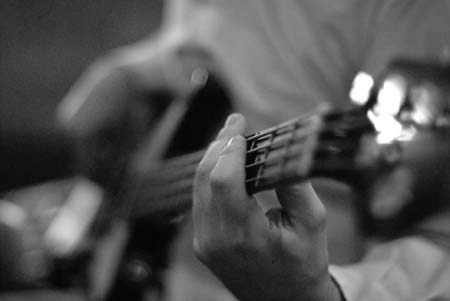 Nærbillede af hånd på en guitarhals